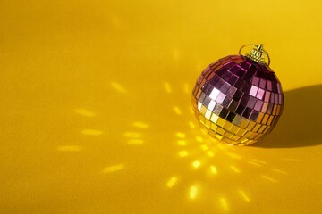 Retro Disco Ball on Yellow Background with Reflecting Light. Decorations for Parties and Christmas.