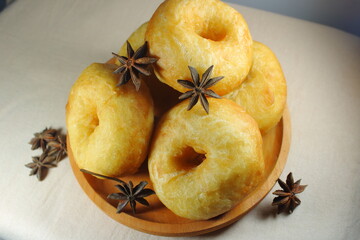 Golden brown homemade donuts served on a wooden plate