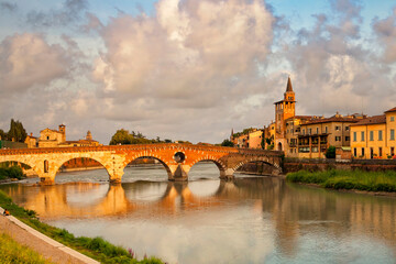 Verona, Italy. Evening landscape at Stone Bridge in Verona. Sunset view of Bridge Ponte Pietra in Verona on Adige river, Veneto region, Italy.