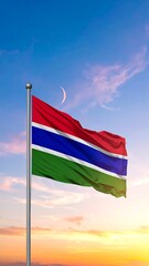 Gambia flag waving in a vibrant sunrise/sunset sky