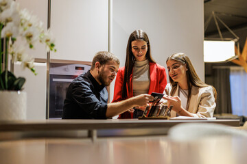 Colleagues collaborating on kitchen design ideas in office