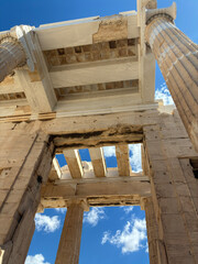 Close up detail of Parthenon columns in Athens creating artistic ancient architectural lines and textures under bright sunlight and blue sky.