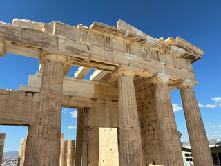 Close up detail of Parthenon columns in Athens creating artistic ancient architectural lines and textures under bright sunlight and blue sky.