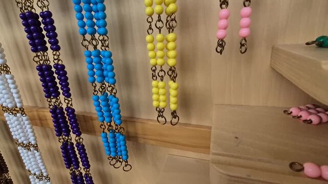 Montessori education. Multicolored cubes and beads on a shelf for learning math according to the Montessori method. Alternative education in elementary school.