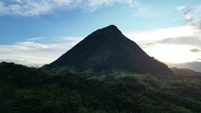 Aerial view of Cerro Tusa, the pyramid-shaped mountain near Venecia in the Antioquia region of Colombia, rising from the green highlands of the Western Andes during a picturesque sunset