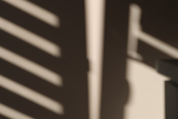 Abstract shadows and light patterns on beige wall