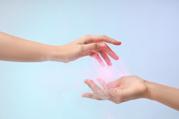 Female hands with ball of pink energy on blue background