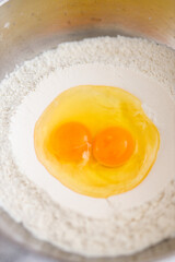 Baking ingredients: eggs and flour in mixing bowl