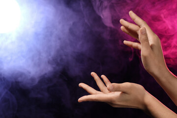 Female hands with energy ball on black background