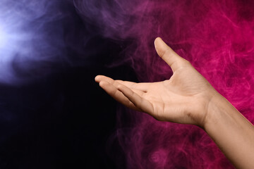 Female hand with pink energy on black background