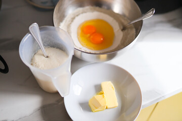 Baking ingredients with eggs and butter in kitchen setting