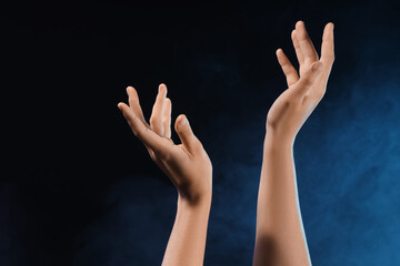 Female hands with blue energy on black background