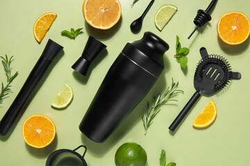Modern bartender kit and cocktail ingredients on green background