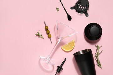 Modern bartender kit, cocktail ingredients and glass on pink background