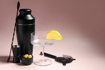 Modern bartender tools, glass and ingredients on pink background