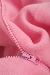Metal zipper on pink fleece fabric. Clothing macro.