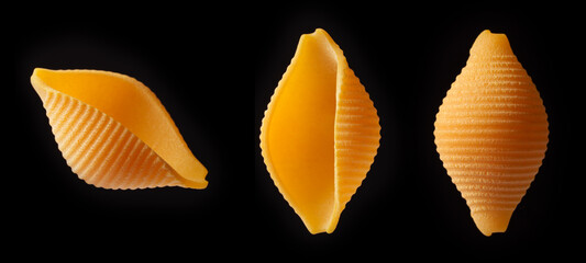 Close-up of dry shell-shaped pasta on a black background.