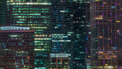 Obraz premium Modern office building with glowing windows at night timelapse. Moscow city