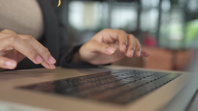 Close up of woman s hands using laptop with natural bokeh background. Technology data entry, and modern work style.