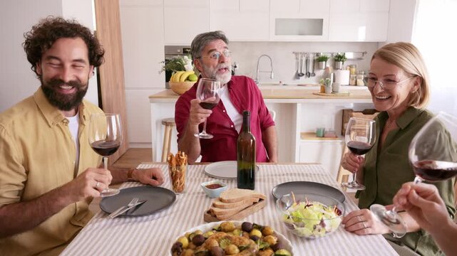 Happy multi generational family toasting with wine during lunch