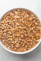 Overhead view of beans being washed, top view of honey beans being washed to make nigerian moi-moi or bean cake, process of peeling beans skin by hand