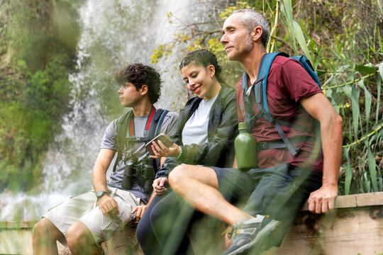Family enjoying nature by waterfall having a rest