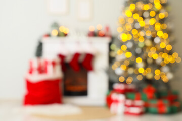 Blurred view of festive room with Christmas tree, glowing lights and fireplace