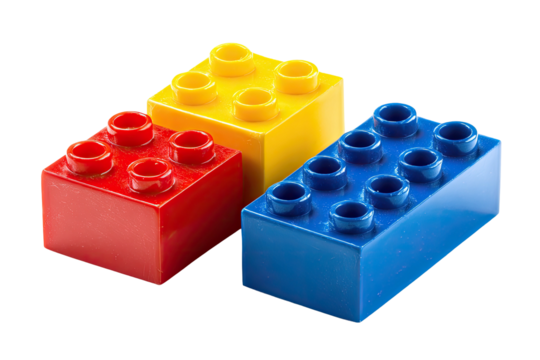 Three primary color plastic building blocks arranged on a dark background, showing top stud details