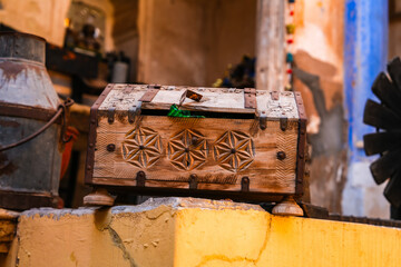old wooden box, Ornate wooden chest with metal straps and carved star and floral patterns, showcasing traditional folk craftsmanship and antique design.