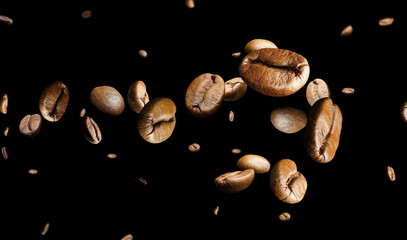 Coffee beans form a spiral pattern on a black background