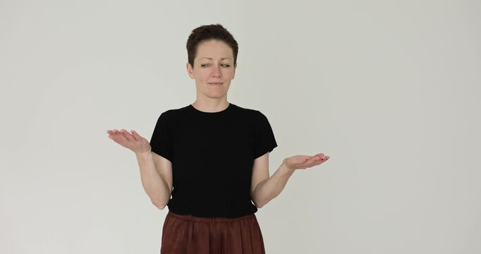 Lady presenter raises palms at shoulder height showing balance idea. Speaker moves hands side to side weighting options like simple scale slow motion