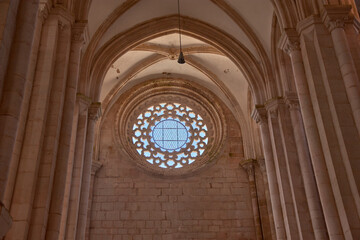 Interior view of the Alcobaca Monastery with a symmetrical rose window and vaulted ceiling in a heritage and solemn space