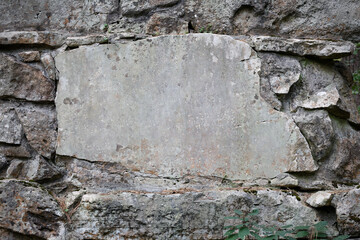 Empty sign board with copy space for inscription in stone wall.