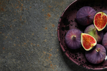 Bowl with fresh ripe figs on grunge background