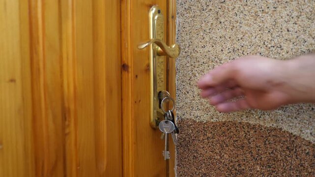 A man locks the front door with a key.