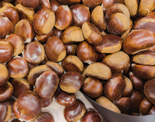 Close-up of fresh brown chestnuts piled together as a natural autumn food background