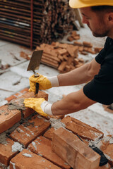 In yellow colored protective helmet. A builder is working at the construction site at daytime