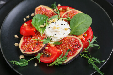 Plate of tasty fig salad on black background, closeup