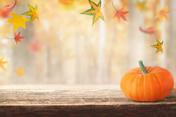 wooden table and a blurry autumn background.  background with autumn leaves and a beautiful pumpkin, product presentation.