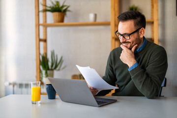 Business man accountant analyst holding documents, work at laptop computer doing online trade market