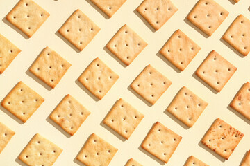 Tasty salty crackers on beige background