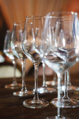 Empty wine glasses arranged on a wooden table in an elegant setting