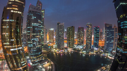 Fototapeta premium Residential and office buildings in Jumeirah lake towers district day to night timelapse in Dubai