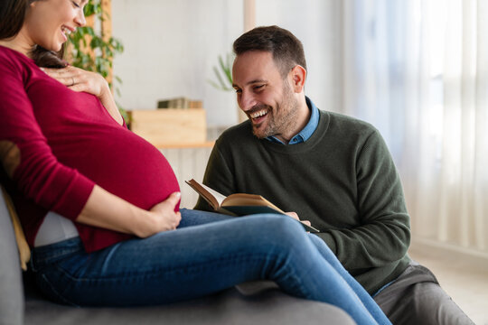 Beautiful pregnant woman and her handsome husband are smiling while spending time together - Powered by Adobe