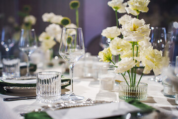 Elegant dining table setting with white flowers and glassware for special event