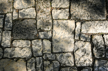 Antique cobblestone in the sun. Top view.