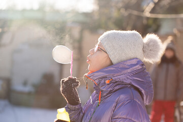 Child blowing bubbles in frosty sunshine
