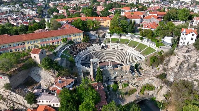 Plovdiv aerial drone view highlighting Ancient Roman Theatre, red roof houses, historic city Bulgaria, amphitheater cultural landmark. The central post office and neighbourhoods of Philippopolis