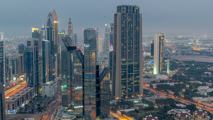 Naklejka premium Dubai International Financial Centre district with modern skyscrapers day to night timelapse