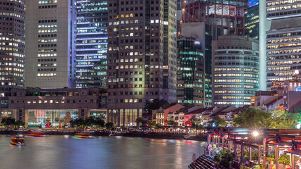 Naklejka premium Singapore quay with tall skyscrapers in the central business district on Boat Quay day to night timelapse